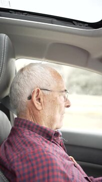 video of retired elderly man over eighty driving, video from the co-driver to the driver, serious man with glasses and hearing aids, serious man watching the road