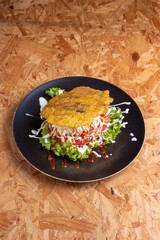 Cachapa o chapa , gastronomia venezolana, en plato negro con fondo de  madera