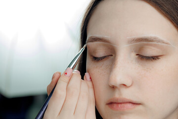 Brow correction, Master tweezers depilation of eyebrow hair in women