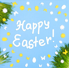 Happy Easter card with frame of green grass, decorative white and yellow eggs and flowers on blue.