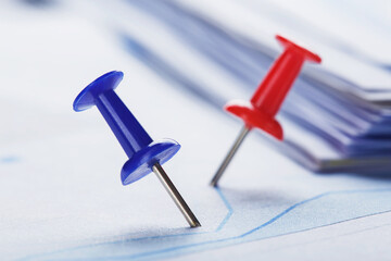 Marking financial chart by pins.Share listing and checking financial chart. Concept of banking, financial report and financial audit.