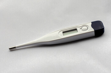 Electronic medical thermometer on a light background