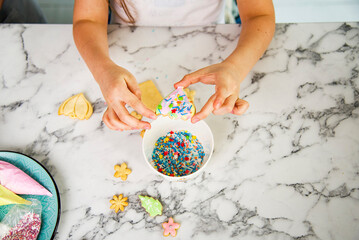 children painting the easter cookies on the table