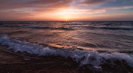 Sunset over the sea shore, waves