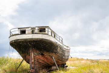 Old derelict wooden ship wreck closeup. Back side of an old abandoned boat coastline In Estonia