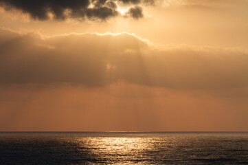 Seascape: sunrays break through the clouds on the water surface
