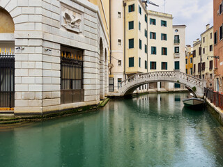 Romantische alte Brücke in Venedig vor einem modernen Gebäude