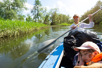 Family kayak trip. Father and daughter rowing boat on the river, a water hike, a summer adventure. Eco-friendly and extreme tourism, active and healthy lifestyle
