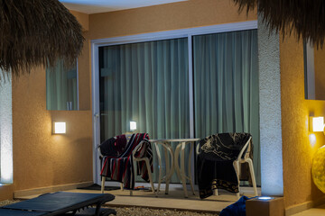 View of towels on outdoor furniture on patio outside of hotel room. Aruba. 
