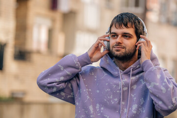 Obraz premium young man enjoying listening to music with headphones outdoors