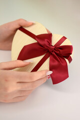 Valentine's Day. gift box in the shape of a heart in the hands of a girl. love banner or greeting card