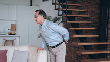 Elderly man standing with pain in back