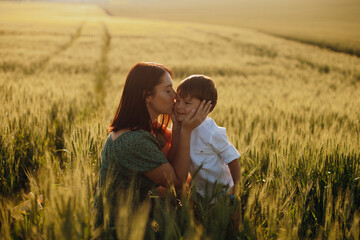 Happy family mother and child son walking on nature at sunset