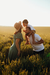 Happy family father and mother and child son walking on nature at sunset