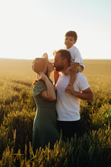 Happy family father and mother and child son walking on nature at sunset