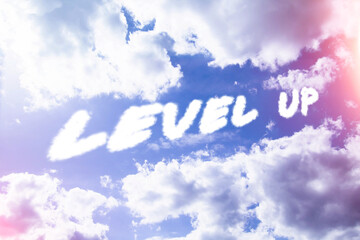 Level up. Text from clouds in sky in bright sunlight.