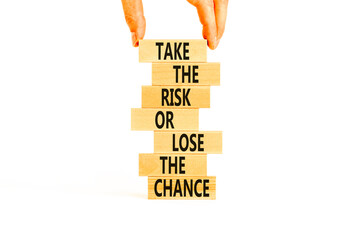 Risk or chance symbol. Concept words Take the risk or lose the chance on wooden blocks. Beautiful white background. Copy space. Businessman hand. Motivational business risk or chance concept.