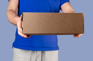 Hands holding, giving brown cardboard box, carton package, man in blue volunteers t shirt