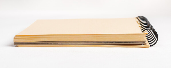 Sketchbook, spiral bound sketch book with blank yellow paper sheets side view