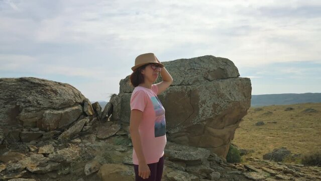 Girl with a hat impressed with the nature. Girl standing and looking around. 4k footage UHD 3840x2160
