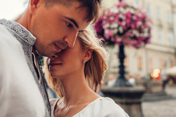 Close up portrait of loving couple walking in old Lviv city wearing traditional national ukrainian shirts. Space