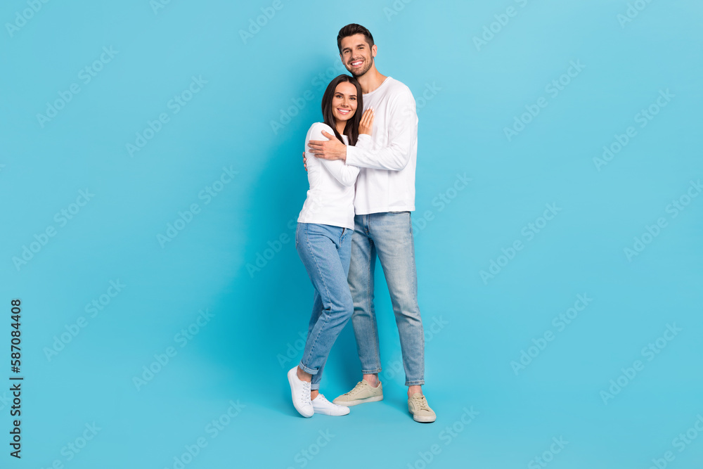 Poster full length portrait of two cheerful nice partners hugging toothy smile isolated on blue color backg