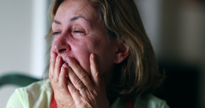 Stressed out older woman in 60s covering face with hands. Anxious worried senior woman feeling anxiety