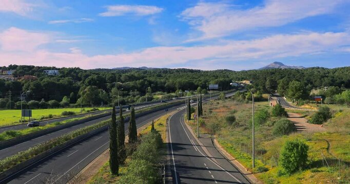 Highway with little traffic in a rural area of the island of Mallorca near the town of Santa Ponsa, It is a day with a gentle breeze and almost entering the golden hour.