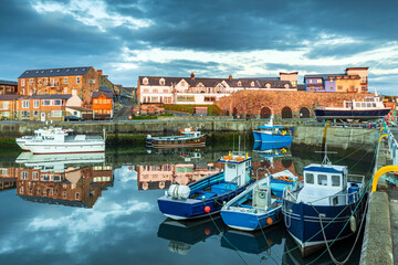 A lovely still morning with the colourful boats reflected in the harbour at Seahouses on the...