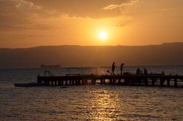 A couple against the sunset on a pier in Aqaba on the Red Sea
