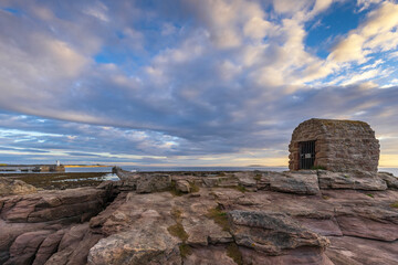 The Powder House at Seahouses on the Northumberland coast, with a dramatic morning sky.