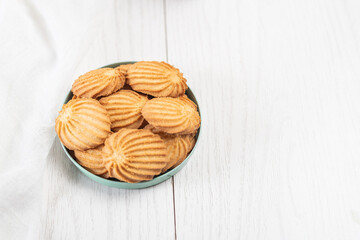 biscuits with orange and vanilla flavors in a plate on white wooden background
