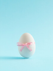White Egg on pastel blue background. Minimal food concept with copy space. Happy Easter.