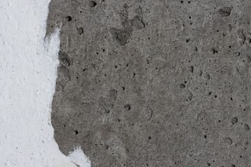 Torn old faded paper wallpaper on a concrete wall. Ragged scraps of white paper on a gray background. Vintage texture for background and design. Closeup view with copy space for text. High resolution.