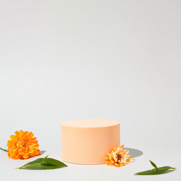Geometric podium platform stand for product presentation and levitate spring flowers on grey background. Mock up scene. Business Concept. Advertisement idea.