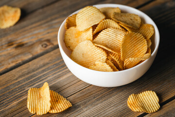 Potatoes chips in bowl good for snack for beer or ale on a natural wooden table. Good for beer festival, pub, restaurant advertising.