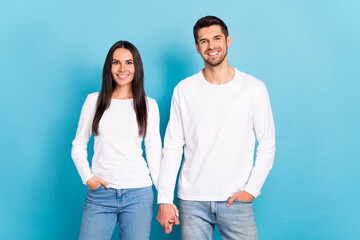 Photo of two nice positive people hold arms toothy smile isolated on blue color background