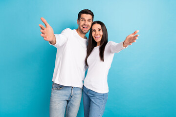 Photo of two impressed cheerful funny positive couple people wear white shirts cuddling glad to see you isolated on blue color background © deagreez