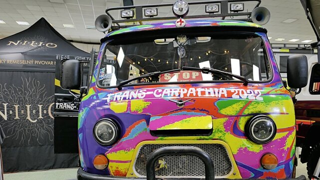 Trans Carpathia Rally soviet van UAZ-452  painted in vivid psychedelic colours, displayed on Caravan bike travel expo in Nitra, Slovakia, march 2023. 