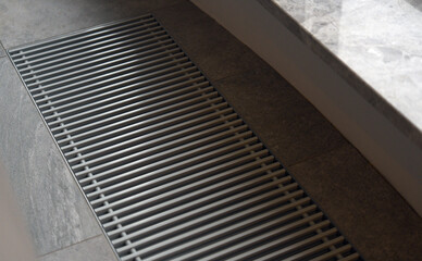Heating grill with ventilation in the floor in laminate.. Forced hot-air heating systems are extremely popular and feature vents like this to channel the hot air throughout the house.