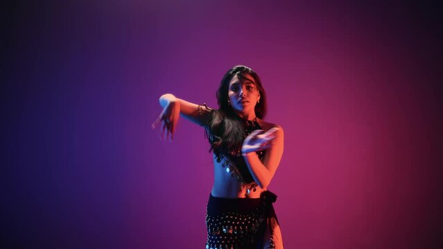 Asian woman belly dancer plastic flex movement performance posing at dark neon backlit studio