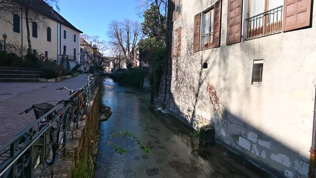 Annecy, France. January 2023. Beautiful daytime footage on a secondary channel in the historic center, intimate and fairy-tale atmosphere. Bicycles parked along the canal railing.