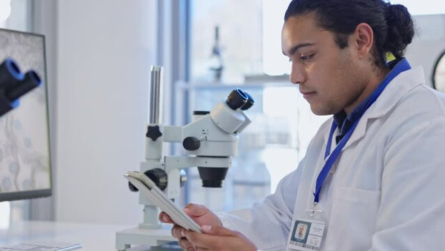 Digital tablet, microscope and scientist in lab doing pharmaceutical research on the internet. Technology, science and professional male scientific researcher working with mobile device in laboratory