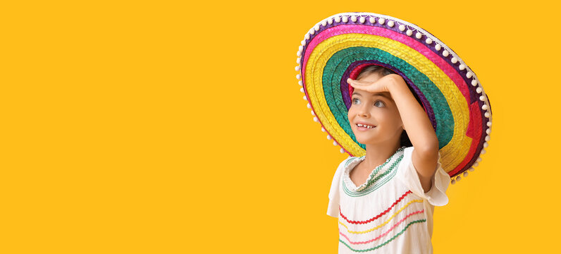 Happy little Mexican girl in sombrero hat on yellow background with space for text