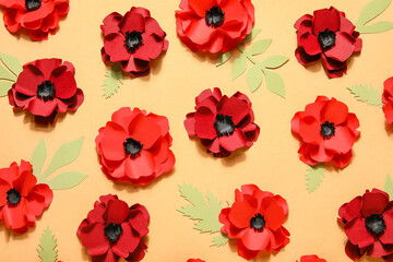Paper poppy flowers with leaves on beige background