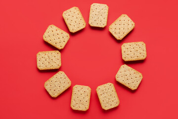 Frame made of tasty crackers on red background