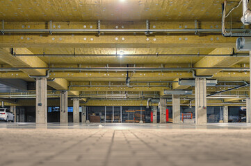 Empty underground parking lot, thermal and acoustic insulation on the ceiling.