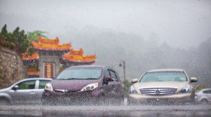 Cars under torrential rain. Heavy tropical rain on city street. Rainy season in Asia, weather...