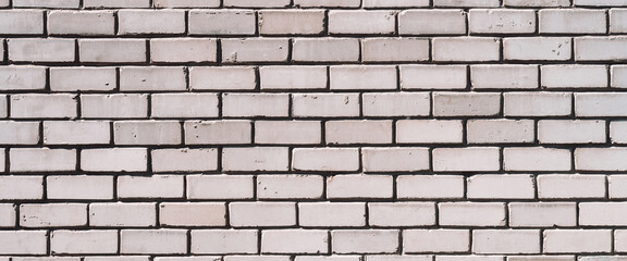 Grayscale backdrop with old realistic white brick wall. Minimal fragment of brickwall close-up. Minimalist monochrome background with wall of gray bricks in different shades. Simple wall texture.