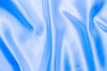 Blue shiny texture of silk satin satin with folds.
